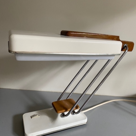 La Lampe de Bureau Fase 1969, une lampe de bureau blanche vintage aux accents en bois et à la structure en métal, est posée sur une surface grise. Brocante 93