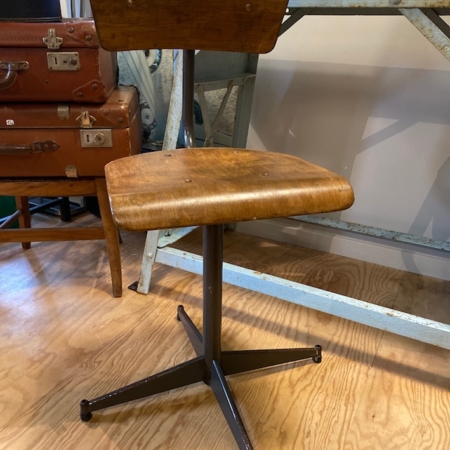 Trouvaille brocante 93, cette "Chaise d'Ecole de Science 1970 VENDU" vintage à piètement en métal repose sur un plancher en bois, à côté d'une table en métal et de vieilles valises. Brocante 93
