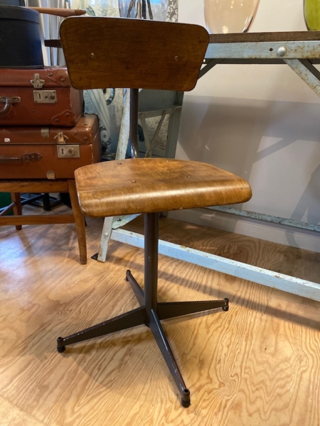 Trouvaille brocante 93, cette "Chaise d'Ecole de Science 1970 VENDU" vintage à piètement en métal repose sur un plancher en bois, à côté d'une table en métal et de vieilles valises. Brocante 93
