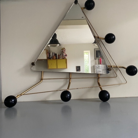 Porte-Manteaux Miroir 1950 VENDU, doté d'un cadre en métal abstrait avec des accents sphériques noirs, ajoute une touche vintage à un mur de couleur claire. Brocante 93