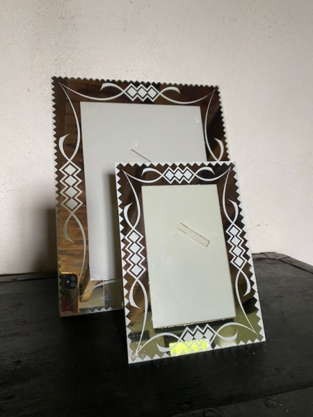 Deux cadres photo décoratifs Cadre Miroir 1960 PM vides, présentant des motifs vintage complexes, sont exposés sur une surface en bois foncé sur un fond uni. Brocante 93