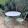 Le Salon de jardin en fer forgé 1960 comprend une table ronde en métal et quatre chaises assorties, parfaites pour une utilisation en extérieur au milieu d'une verdure luxuriante. Brocante 93