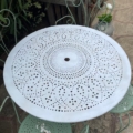 Le Salon de jardin en fer forgé 1960 est doté d'une table ronde en métal au motif perforé et de chaises en métal vert vintage, ajoutant un charme intemporel à tout espace extérieur. Brocante 93