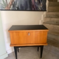 Une paire de tables de nuit 1950 aux pieds noirs se dresse près de l'escalier, sous une peinture murale de paon, ajoutant un charme vintage à l'espace. Brocante 93