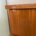 Gros plan d'une Paire de tables de nuit 1950 avec une finition en bois lisse, ressemblant à des tables de chevet classiques, posées contre un mur de couleur claire. Brocante 93