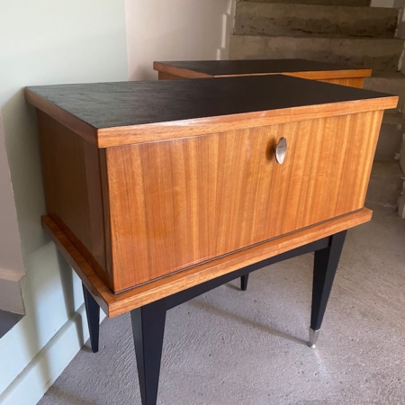 Paire de tables de nuit 1950 en bois, avec pieds noirs et porte, disposées près des escaliers en intérieur. Brocante 93
