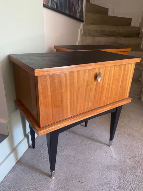 Paire de tables de nuit 1950 en bois, avec pieds noirs et porte, disposées près des escaliers en intérieur. Brocante 93