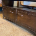 Le Meuble industriel métal riveté est un meuble en bois marron avec deux tiroirs et poignées rivetées en métal, ajoutant de l'élégance à n'importe quel plancher en bois. Brocante 93