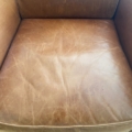 Paire de fauteuils Club 1940 : fauteuils en cuir marron avec plis et marques d'usure visibles sur le coussin d'assise, évoquant le style Club classique et vintage des années 40. Brocante 93