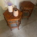 Une paire de chevets bambou 1970 avec des vases, dont l'un présente des fleurs violettes, est posée sur un sol en béton à côté d'un mur vert clair. Brocante 93