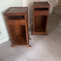 Deux tables de nuit en bois avec des étagères ouvertes et un seul tiroir, placées sur un sol en béton près d'un escalier. Brocante 93
