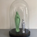 Le Globe de mariage 1950 présente deux statues de la Vierge Marie, l'une verte et l'autre argentée, sous un dôme de verre à base noire, inspiré des globes de mariage français classiques. Brocante 93