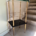 La table d'appoint Sellette verre et laiton 1950 avec un design à deux niveaux or et noir se trouve à côté d'un escalier sur un sol en béton. Brocante 93