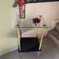 La Sellette verre et laiton 1950 présente un vase de fleurs rouges surmonté d'une seule fleur rouge, élégamment placée près de l'escalier. Brocante 93