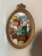 Le Miroir ovale 1950 ajoute un charme vintage à une pièce animée par des lampes colorées, des armoires rétro et des meubles élégants des années 1950. Brocante 93
