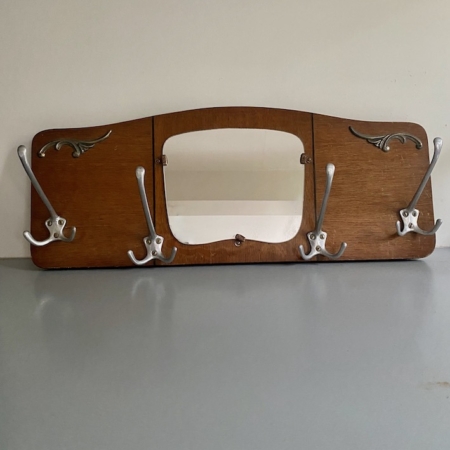 La peinture murale Porte-manteaux 1940 est composée d'un cadre en bois, de crochets en métal et d'un miroir rectangulaire central, ce qui confère un charme des années 1940 à n'importe quel mur ordinaire. Brocante 93