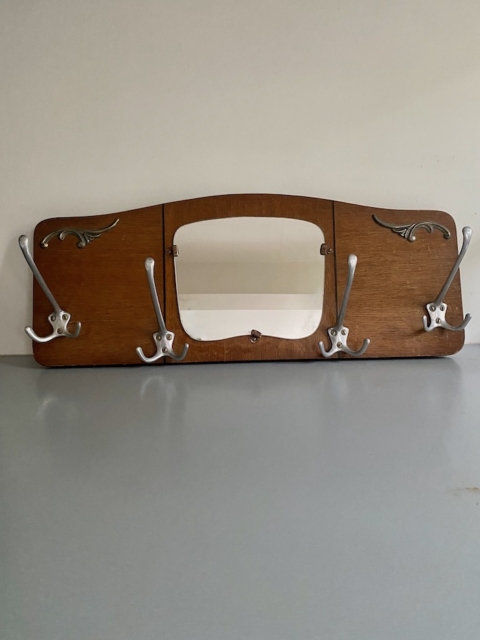 La peinture murale Porte-manteaux 1940 est composée d'un cadre en bois, de crochets en métal et d'un miroir rectangulaire central, ce qui confère un charme des années 1940 à n'importe quel mur ordinaire. Brocante 93
