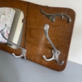 La murale Porte-manteaux 1940 comprend deux patères en métal, un élément décoratif en métal et un miroir intégré pour une touche vintage. Brocante 93
