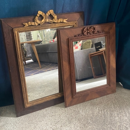 Deux miroirs en bois Miroir noeud PM 1940 ornés de nœuds délicats reposent sur un sol moquetté devant un rideau bleu et un canapé gris, rayonnant d'une élégance raffinée. Brocante 93