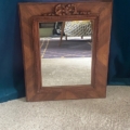 Le Miroir noeud PM 1940, doté d'un cadre en bois et d'un dessus en noeud sculpté, est adossé à un mur bleu sur un sol recouvert de moquette. Brocante 93