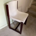 La Chaise Gautier 1970, une chaise moderne blanche avec des pieds en bois foncé, est placée près de l'escalier sur un sol clair. Brocante 93