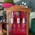 La Vitrine murale vintage 1950, ornée de bougies, de gobelets et de décorations, ajoute du charme à une pièce confortable et éclectique. Brocante 93