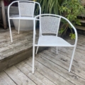 Une paire de fauteuils de jardin est installée sur une terrasse en bois entourée de verdure luxuriante et d'escaliers en bois, créant un espace extérieur paisible. Brocante 93