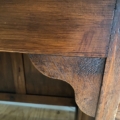 Gros plan sur le coin en bois vintage du Bureau des années 1960, mettant en évidence les détails décoratifs sculptés et le grain visible qui témoignent d'un savoir-faire vintage classique. Brocante 93