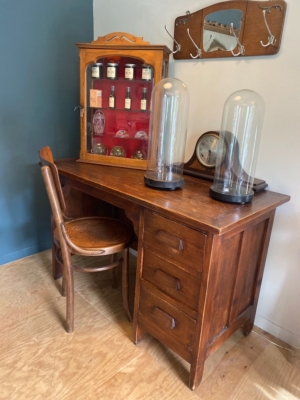 Le Bureau maitre d'école 1960 se trouve à côté d'une armoire et de crochets muraux, associés à des bocaux, des horloges et des coupoles en verre pour créer l'espace de travail vintage parfait. Brocante 93
