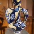 Le vase EVENEMENT.... est un vase abstrait en céramique bleue et blanche avec des motifs tourbillonnants, présenté sur un piédestal à l'intérieur - parfait pour ajouter une sophistication artistique à n'importe quel décor. Brocante 93