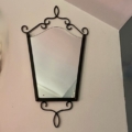 Le Miroir fer forgé vintage 1950 présente un cadre en métal noir avec d'élégantes volutes, apportant un charme vintage et une sophistication à tout mur de couleur claire. Brocante 93