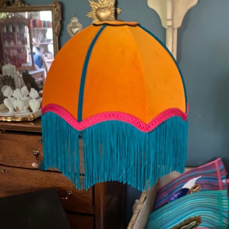 L'abat-jour Baladeuse bohème chic rose, avec son orange vif, ses franges bleues et ses bordures roses, ajoute une touche vintage élégante à n'importe quelle pièce. Brocante 93