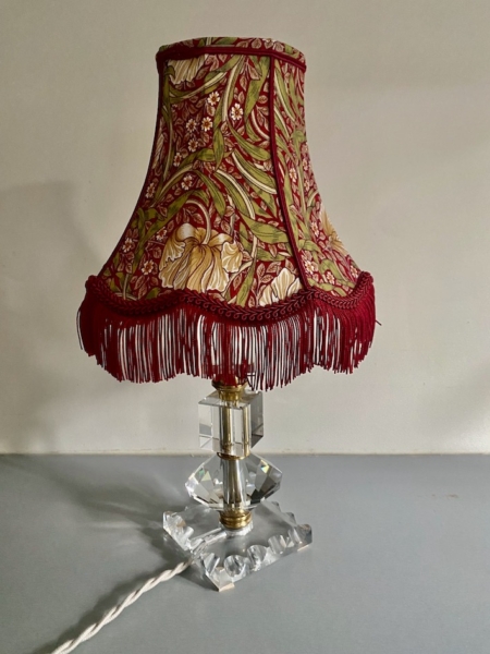La Lampe pied en verre vintage 1940 est dotée d'une base en cristal et d'un abat-jour floral rouge avec franges, parfait pour ajouter un charme authentique des années 1940 à votre décor. Brocante 93