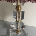 La Lampe pied en verre vintage 1940 présente un verre clair à facettes, des accents en laiton et un bord d'abat-jour frangé rouge pour un look vintage chic. Brocante 93