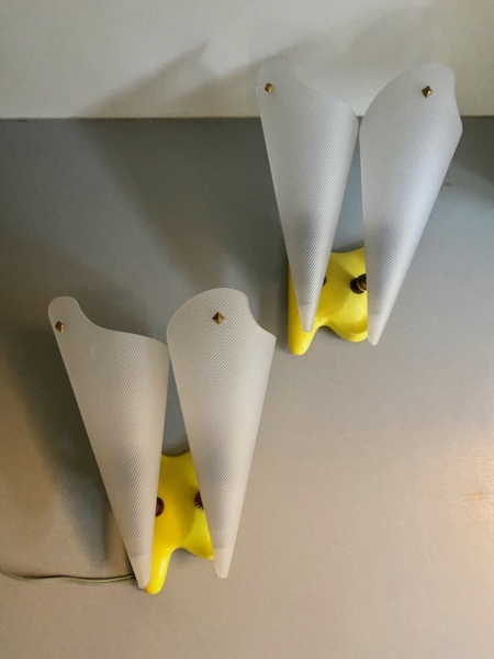 Paire d'appliques vintage 1960 : deux lampes murales blanches en cône, base jaune, montées sur un mur gris clair. Brocante 93