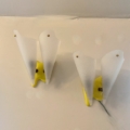 Paire d'appliques vintage 1960 : deux lampes murales blanches en forme de cône, à base jaune, fixées sur un mur texturé clair. Brocante 93