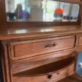 Gros plan sur la console Art Déco 1930, un buffet vintage en bois comportant un tiroir avec une poignée en laiton et un miroir attenant reflétant une pièce lumineuse. Brocante 93