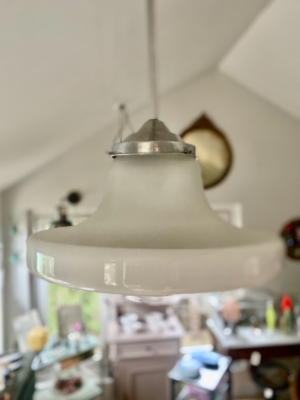 La Suspension verre & opaline 1940, un luminaire vintage en verre blanc opalin, est élégamment suspendu au plafond dans une pièce doucement éclairée. Brocante 93