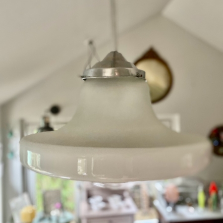 La Suspension verre & opaline 1940, un luminaire vintage en verre blanc opalin, est élégamment suspendu au plafond dans une pièce doucement éclairée. Brocante 93