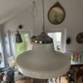 La lampe suspendue Suspension verre & opaline 1940 est suspendue dans une pièce confortable avec une décoration vintage et un miroir rond au mur. Brocante 93