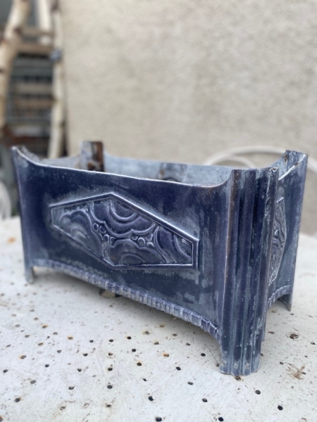 La Jardinière Art Déco 1930 est une pièce rectangulaire ancienne et ornée de motifs en relief, présentés sur une surface perforée de couleur claire. Brocante 93