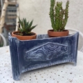 Deux petites plantes succulentes en pot disposées dans la Jardinière Art Déco 1930 reposent sur une table ronde d'extérieur blanche, apportant une touche élégante des années 1930 à votre espace. Brocante 93