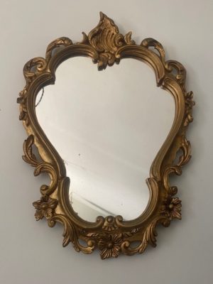 Le Miroir Rococo 1960 présente un cadre doré décoratif avec des motifs floraux et des volutes complexes. Il respire l'élégance vintage et le style rococo classique lorsqu'il est accroché gracieusement à un mur. Brocante 93