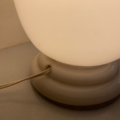 La lampe opaline Art déco 1930 est une lampe de table blanche dotée d'un socle rond et d'un cordon d'alimentation latéral, inspirée des lignes élégantes du style Art déco des années 1930. Elle trône avec grâce sur des surfaces claires, alliant à la perfection un style intemporel à une simplicité fonctionnelle. Brocante 93