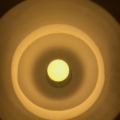 Une lumière jaune éclatante rayonne sous la lampe opaline Art déco de 1930, dont les abat-jours circulaires concentriques reprennent le design emblématique des années 1930. Brocante 93