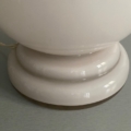 La lampe Art déco opaline de 1930 se caractérise par un pied en céramique blanche brillante posé sur un socle gris, évoquant l'élégance raffinée du style Art déco des années 1930, avec son cordon d'alimentation visible sur le côté gauche. Brocante 93