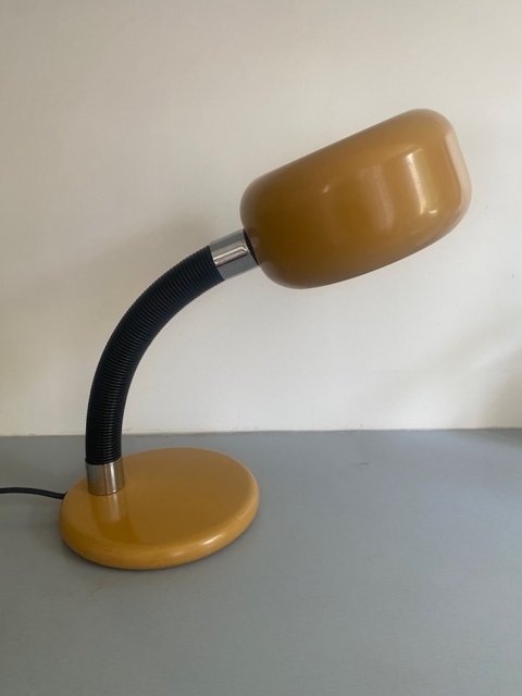 Une lampe de bureau « Lampe berlinoise 1970 » de couleur jaune, dotée d'un bras flexible noir et évoquant le design épuré des années 1970, repose sur une surface gris clair devant un mur blanc. Brocante 93