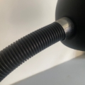 Gros plan sur la « Lampe berlinoise 1970 », dotée d'un bras flexible noir en col de cygne fixé à un socle rond, sur fond blanc, qui rappelle le style vintage. Brocante 93