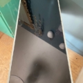 Un miroir rectangulaire posé sur une table reflète un mur sur lequel on aperçoit des fleurs séchées et un miroir au cadre doré, à côté d'un « Meuble de dentiste » datant de 1950, conférant à la scène tout le charme authentique du milieu du siècle dernier. Brocante 93