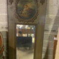 Miroir trumeau du XIXe siècle doté d'un cadre orné, présentant une scène peinte représentant deux personnages au-dessus du miroir, actuellement entreposé. Cette élégante pièce du XIXe siècle apportera une touche historique à n'importe quel intérieur. Brocante 93